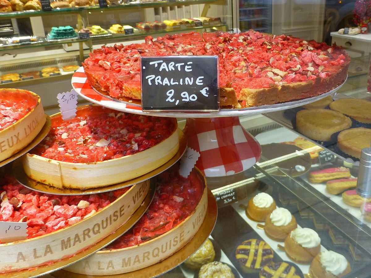 Tartes aux pralines roses dans une vitrine de pâtisserie lyonnaise